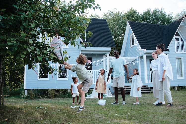 Boy Hitting Pinata With Family