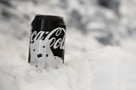 覆盖着霜的可口可乐罐头的特写镜头，被雪包围，给人一种冬日清爽的感觉