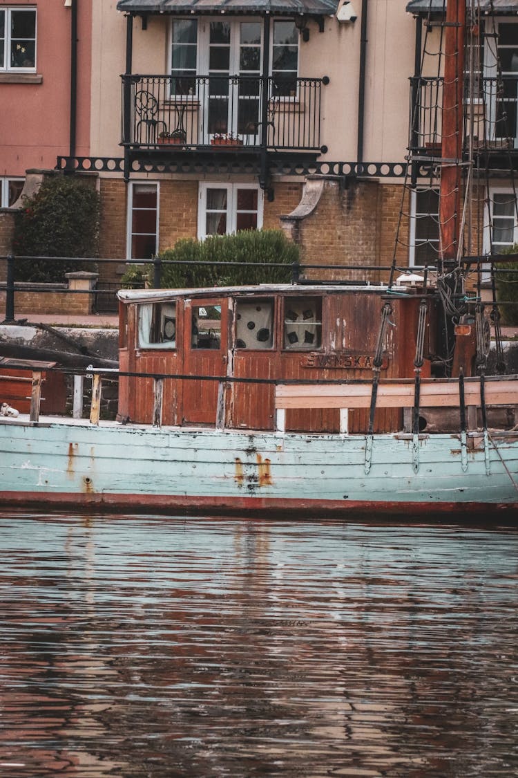 Old Boat Docked By Canal Shore