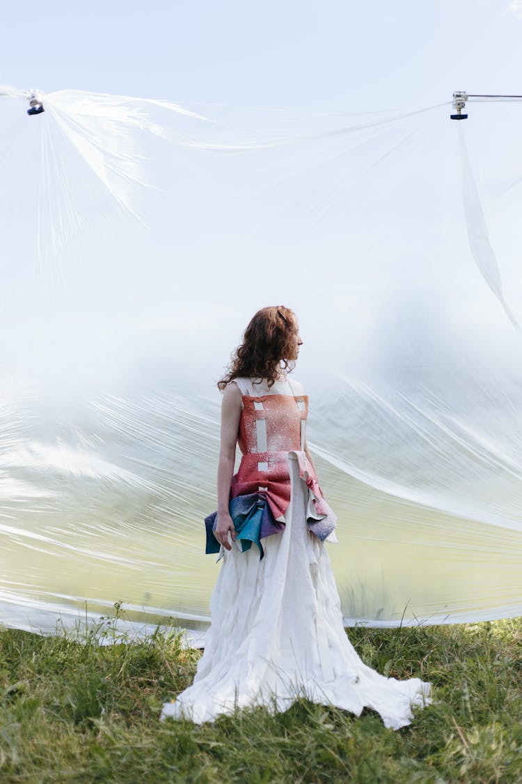 A Woman Standing Beside The Clear Plastic Wall