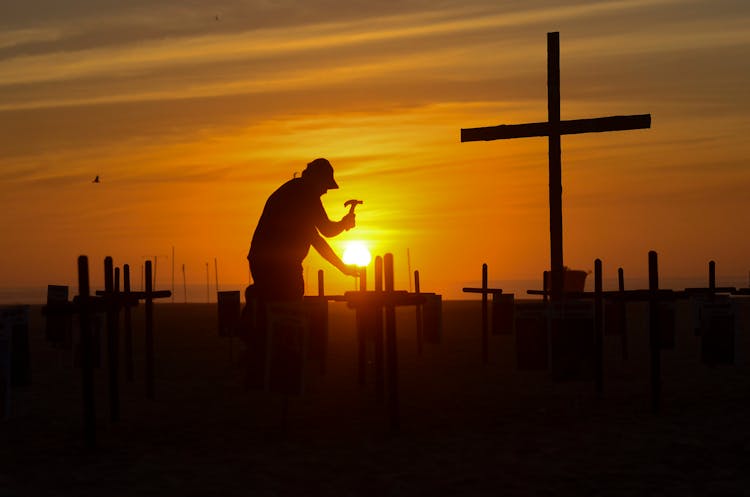 A Man Hammering A Grave Marker