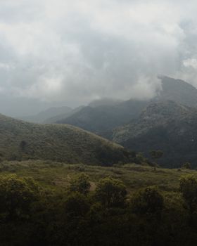 Peaceful view of green mountains and cloudy skies, showcasing natural beauty.
