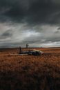 Pilot Standing on Small Airplane Fuselage Laying in Middle of Autumn Fields