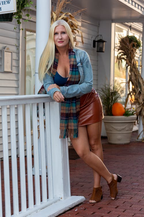 Woman Wearing a Denim Jacket Standing Beside a Wooden Railing