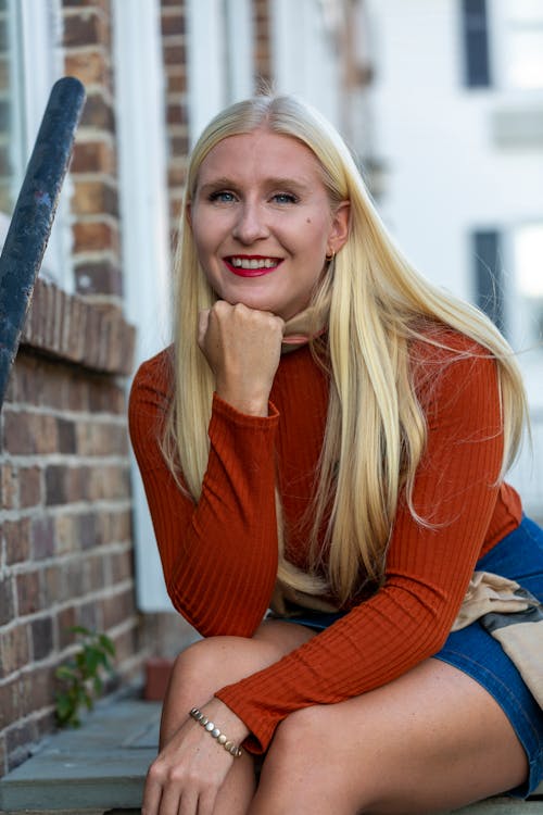 Free A Pretty Blonde-Haired Woman in Brown Sweater Sitting Stock Photo