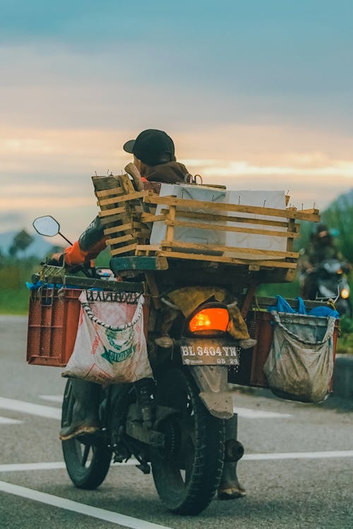 Free A Person Driving a Motorcycle with Crates Stock Photo
