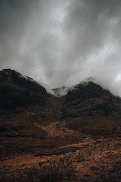 Free Moody landscape of Scottish Highlands with mountains and low clouds. Perfect for nature lovers. Stock Photo