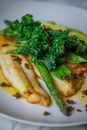 Roast Fish Fillets with Asparagus and Parsley Leaves on Plate