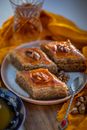 Three Baklava Diamonds on Plate with Tea Spoon