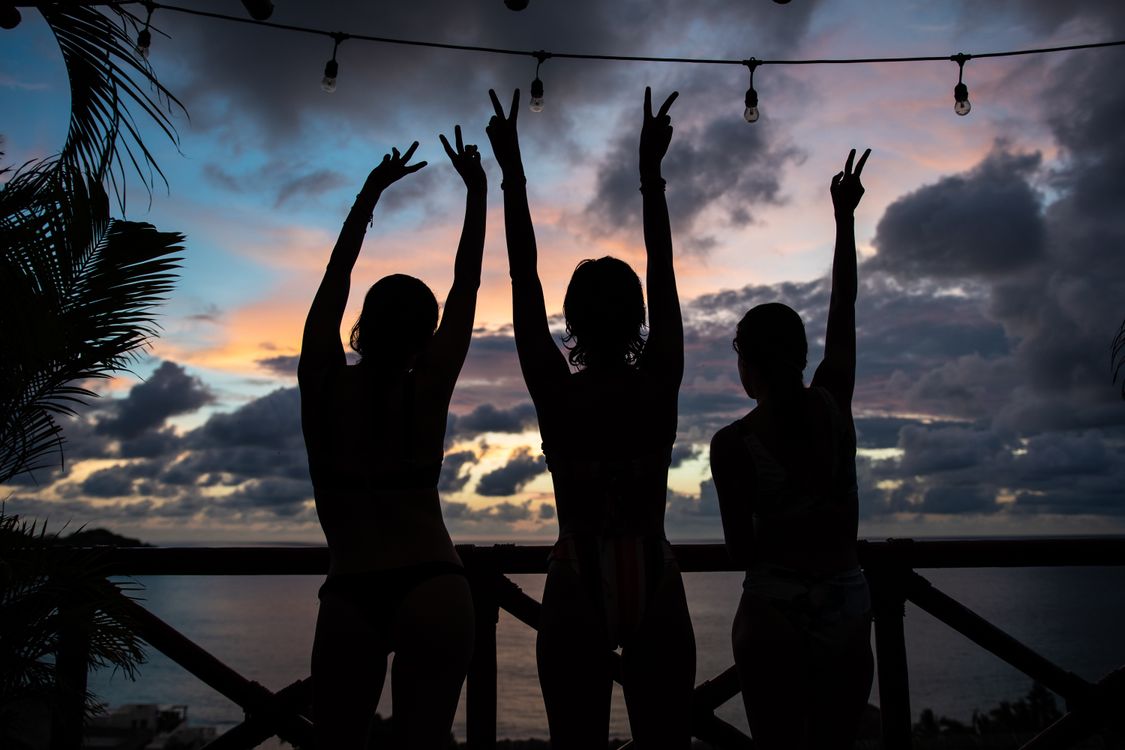 Rear View on Women Standing on Terrace with Raised Arms · Free Stock Photo