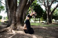 Woman Doing Pull-Ups on Ring in Park