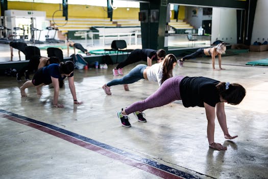 Group of women doing push-ups in a gym reflecting in a mirror.