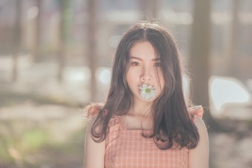 Фотография женщины с цветком на рту
