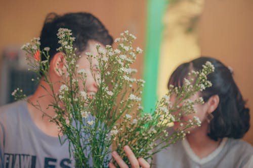 花の後ろの男と女の写真