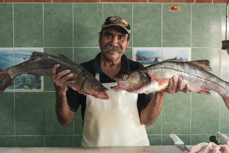 Fishmonger Holding Two Fish