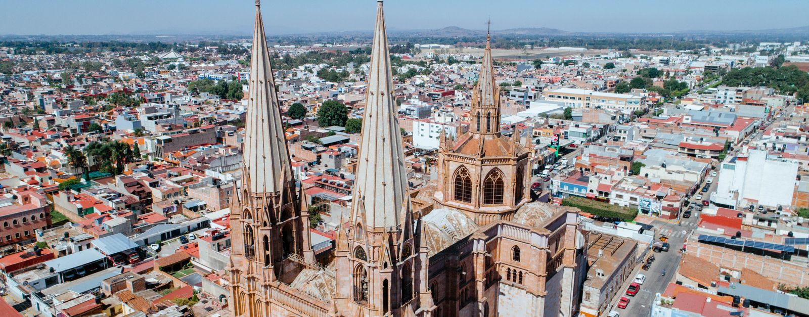 A stunning aerial view of a Gothic cathedral surrounded by the vibrant cityscape of Mexico.