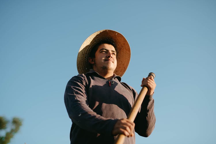 Man Wearing Long Sleeve Shirt Holding A Stick