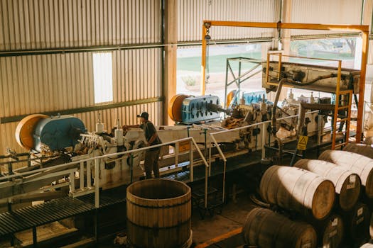 Interior view of a tequila factory with machinery and barrels in Mexico.