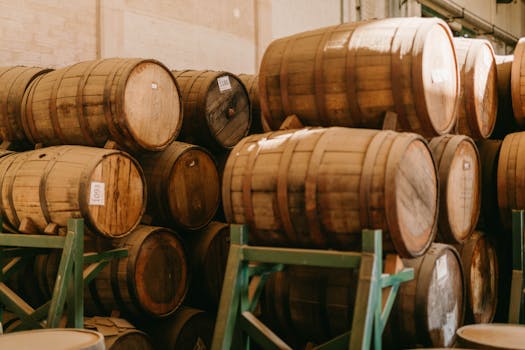 Stacked wooden barrels aging tequila in a Mexican distillery.