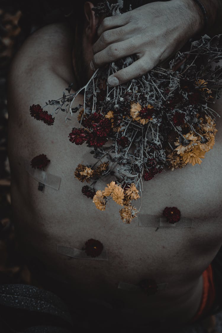 Close-Up View Of Man Back With Patches And Flowers