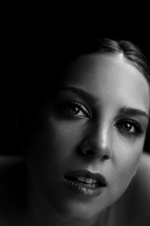 Face of Pretty Young Woman with Tied up Hair Looking at Camera