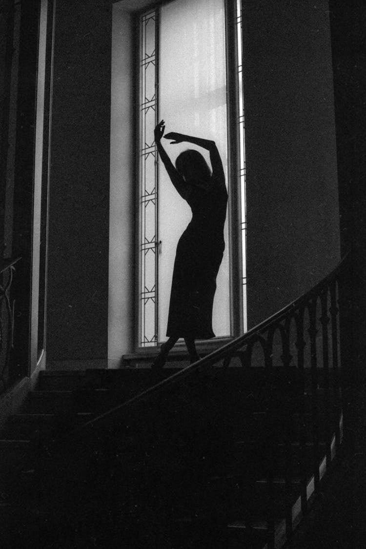 Unrecognizable Female Person Standing On Top Of Stairs With Arms Raised 