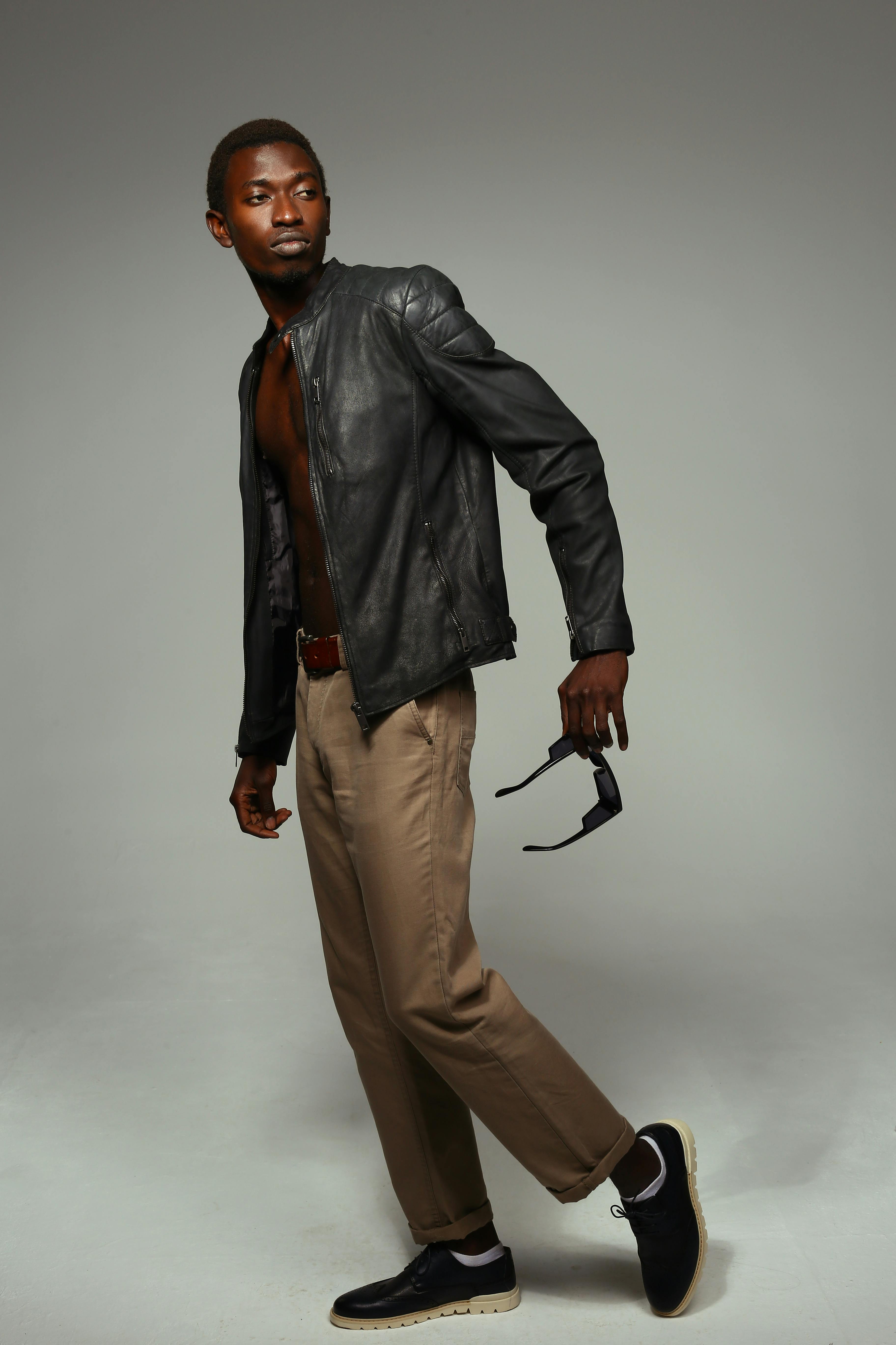 handsome male model posing in beige pants and tweed jacket, on grey Stock  Photo by LightFieldStudios