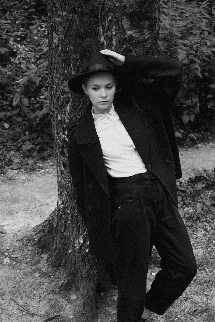 Woman Wearing Male Clothes Standing In Front Of A Tree