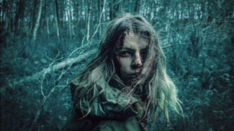 Blonde Girl Covered With Mud And Blood In Gloomy Forest