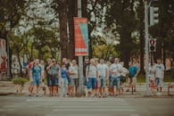 一群不同的成年人在晴朗的日子里站在城市人行横道上等待过马路