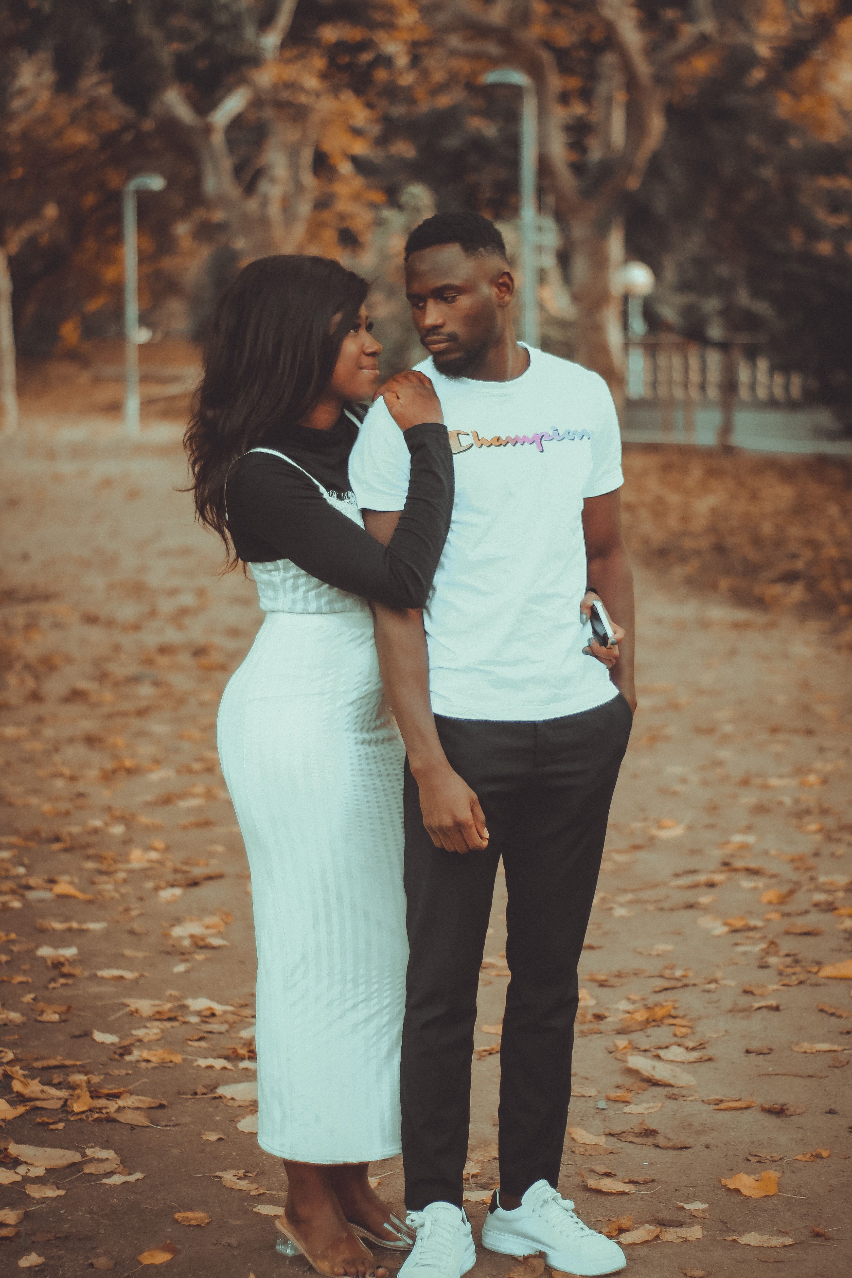 A couple enjoying a peaceful walk together, surrounded by fall leaves.