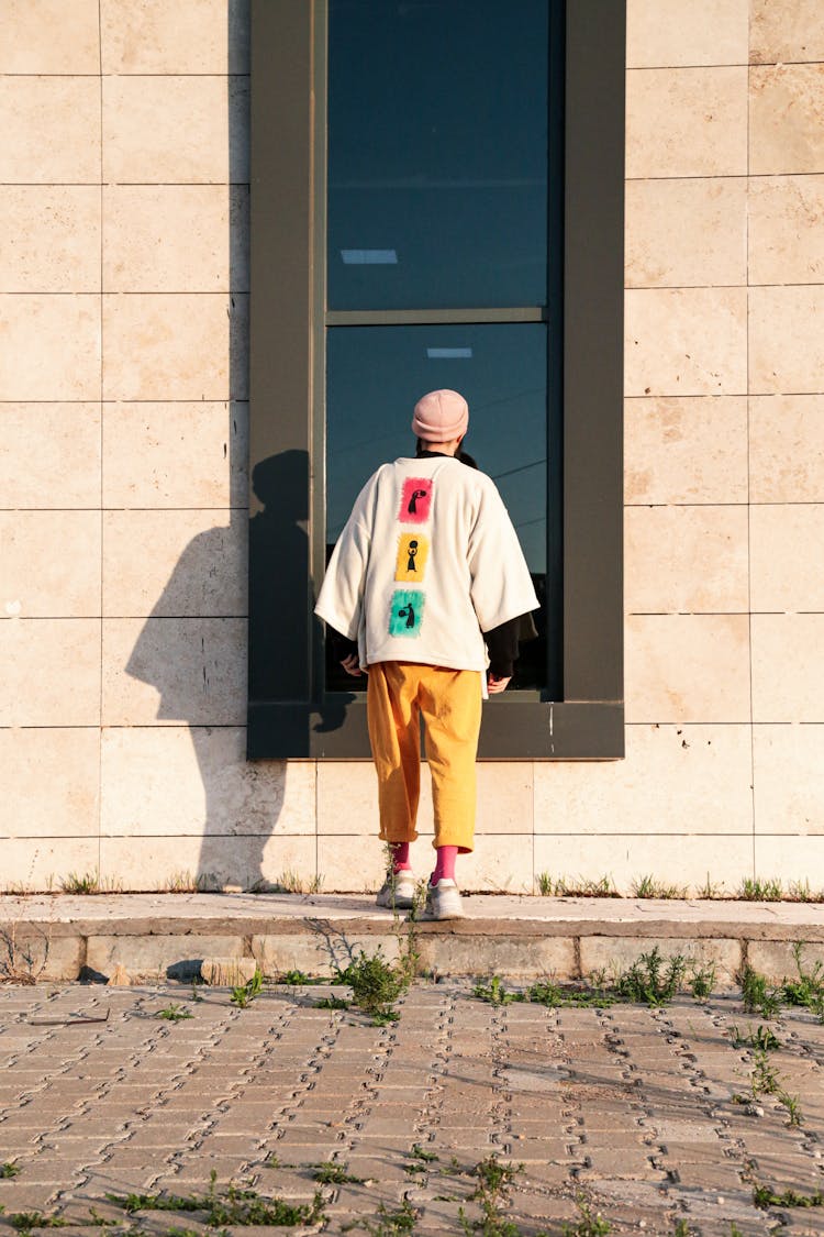 Man In Colorful Clothes Looking Into Window