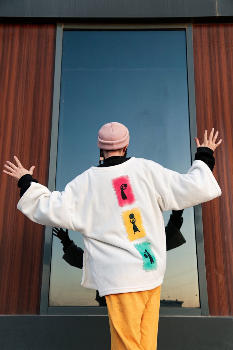 Back View Of A Man Looking At The Tinted Building Window