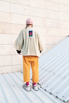 Trendy streetwear fashion with kimono jacket and bold colors on a city rooftop.