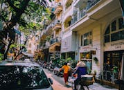 河内街头生活充满活力，阳光明媚，当地人、咖啡馆和摩托车随处可见