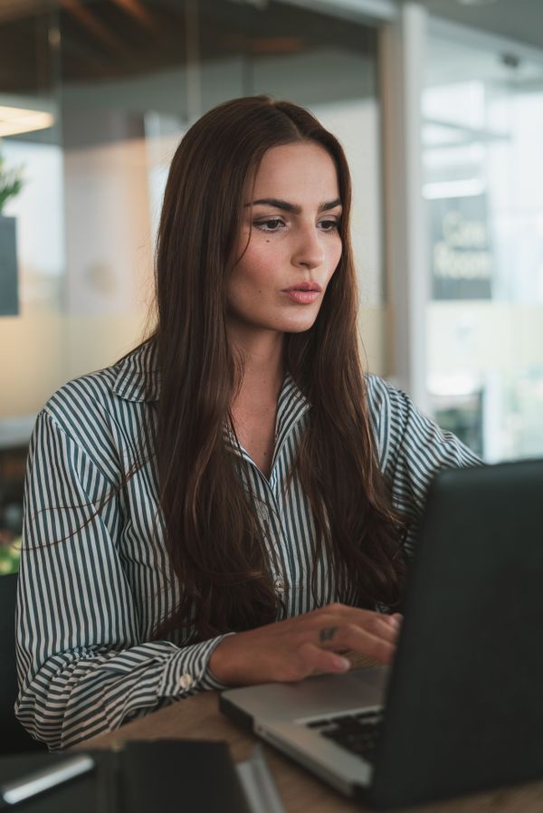 Profesional activa y concentrada trabajando en laptop