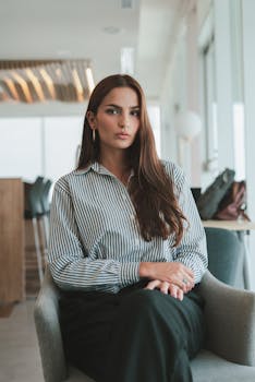 Portrait of a woman sitting in a modern office, embodying professionalism and confidence.