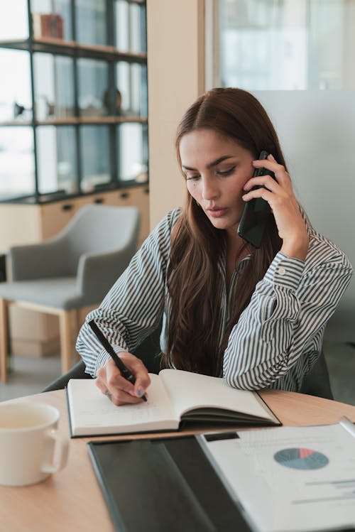 A Female Talking on a Phone in an Office 