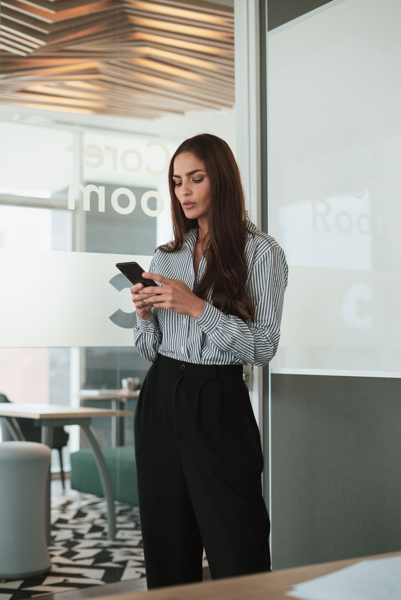 Professional businesswoman using a smartphone in a modern office
