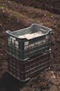 A High Angle Shot of Plastic Crates with Vegetables on Field