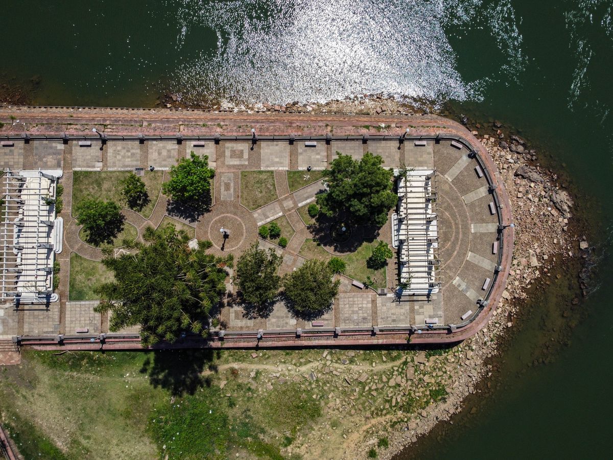 Landscaped waterfront park with trees, lawns, and pedestrian paths. Illustrative stock photo.