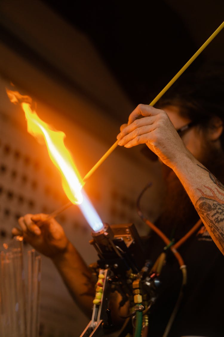 A Person Burning Sticks On A Torch