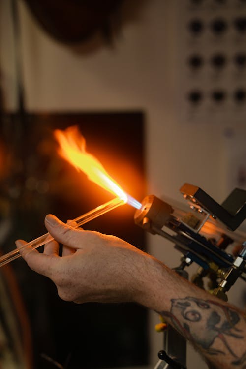 A Person Melting a Clear Stick on a Torch