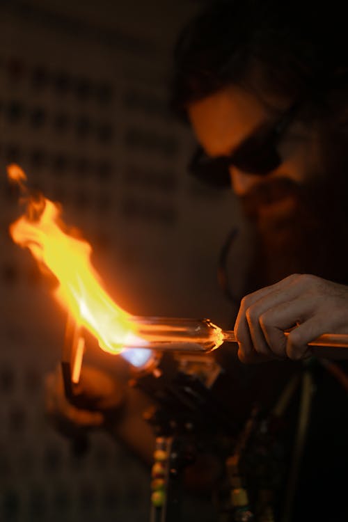 A Man Melting a Glass Tube with a Torch