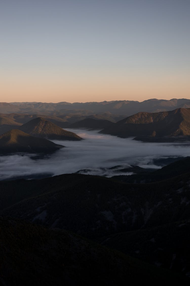 Sunset View Of Mountain Tops Above Clouds