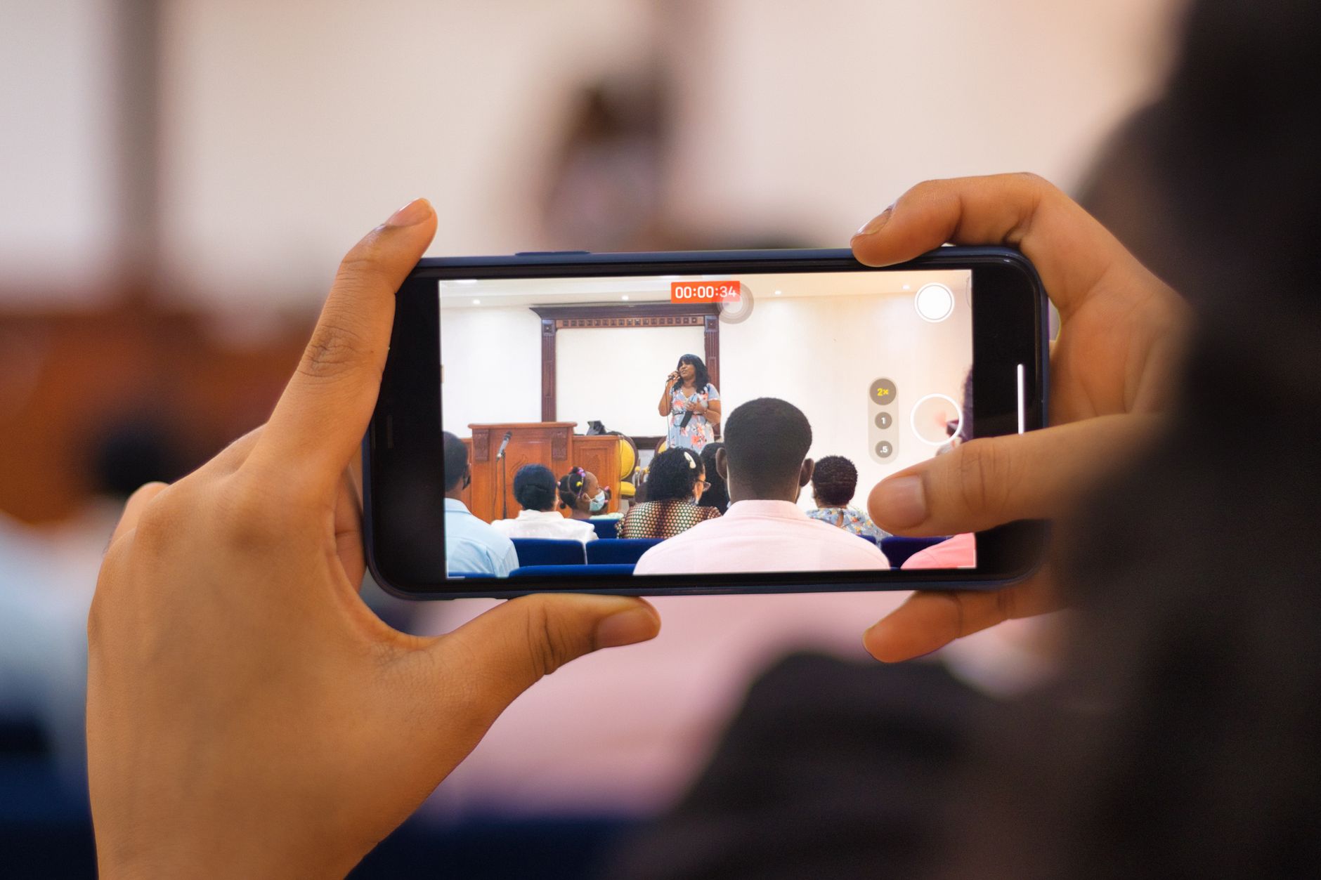 Audience recording a live performance with a smartphone, showcasing modern technology use.