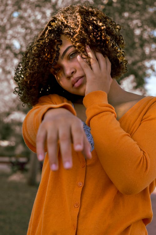 Close Up Photo of Woman Wearing Orange Cardigan