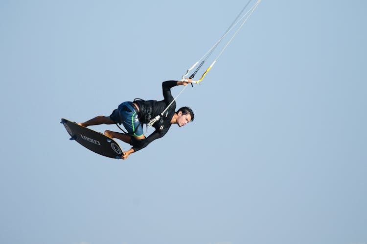 A Man In Black Shirt Paragliding