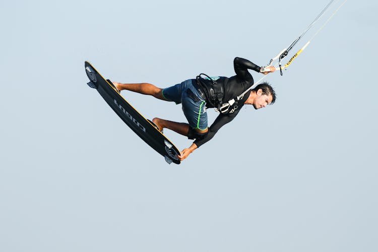 A Man In Black Shirt Paragliding