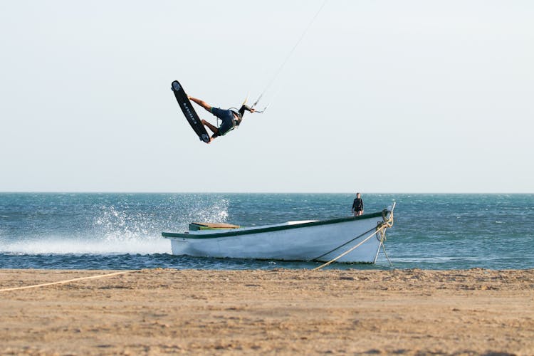 A Man Paragliding In The Beach